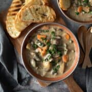 two bowls filled with creamy mushroom stew garnished with parsley.