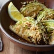 Wedges of seasoned air fryer cabbage in a red bowl.