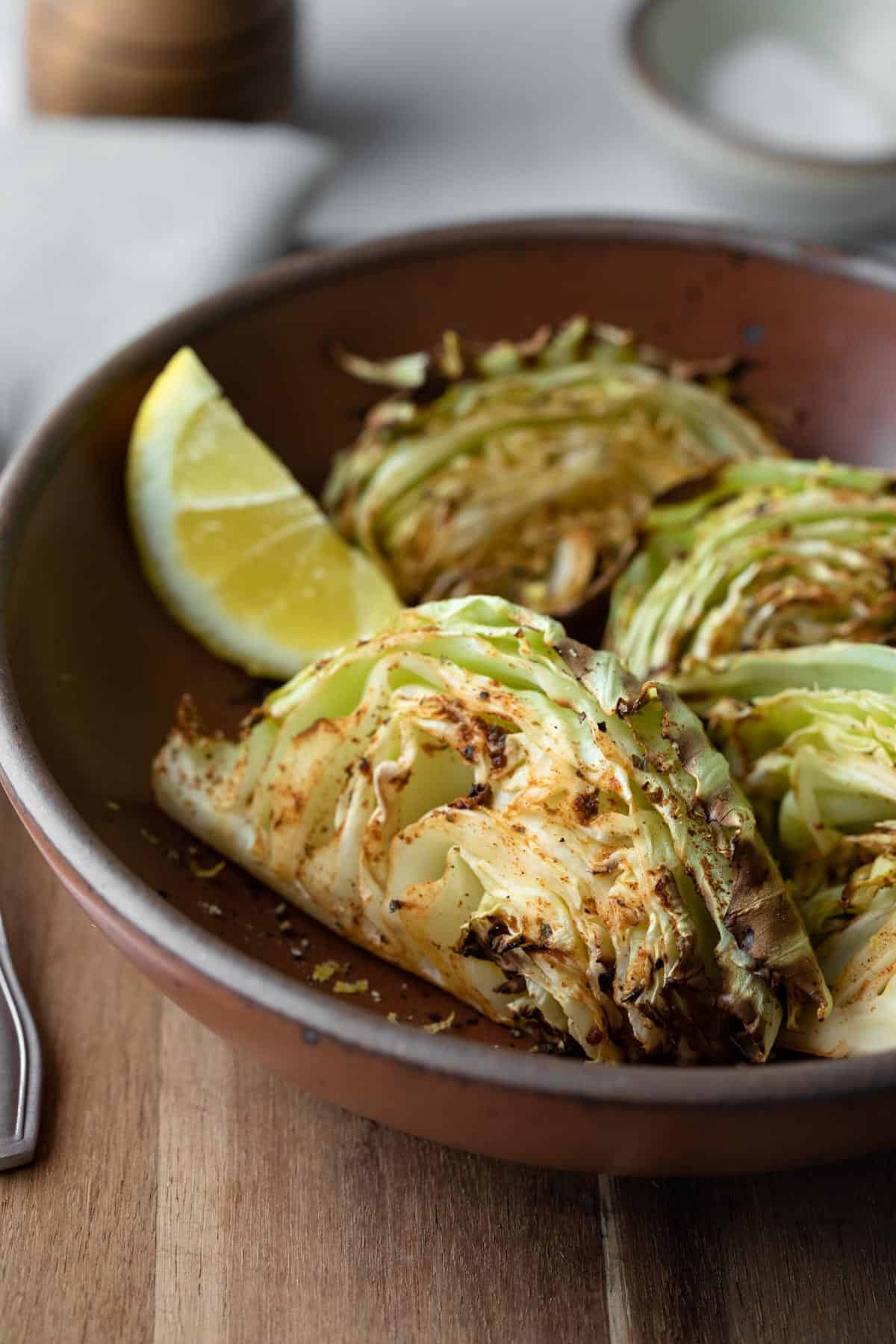 close up of air fryer cabbage wedges in a red bowl.