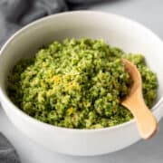 a white bowl filled with lemon-garlic riced broccoli.