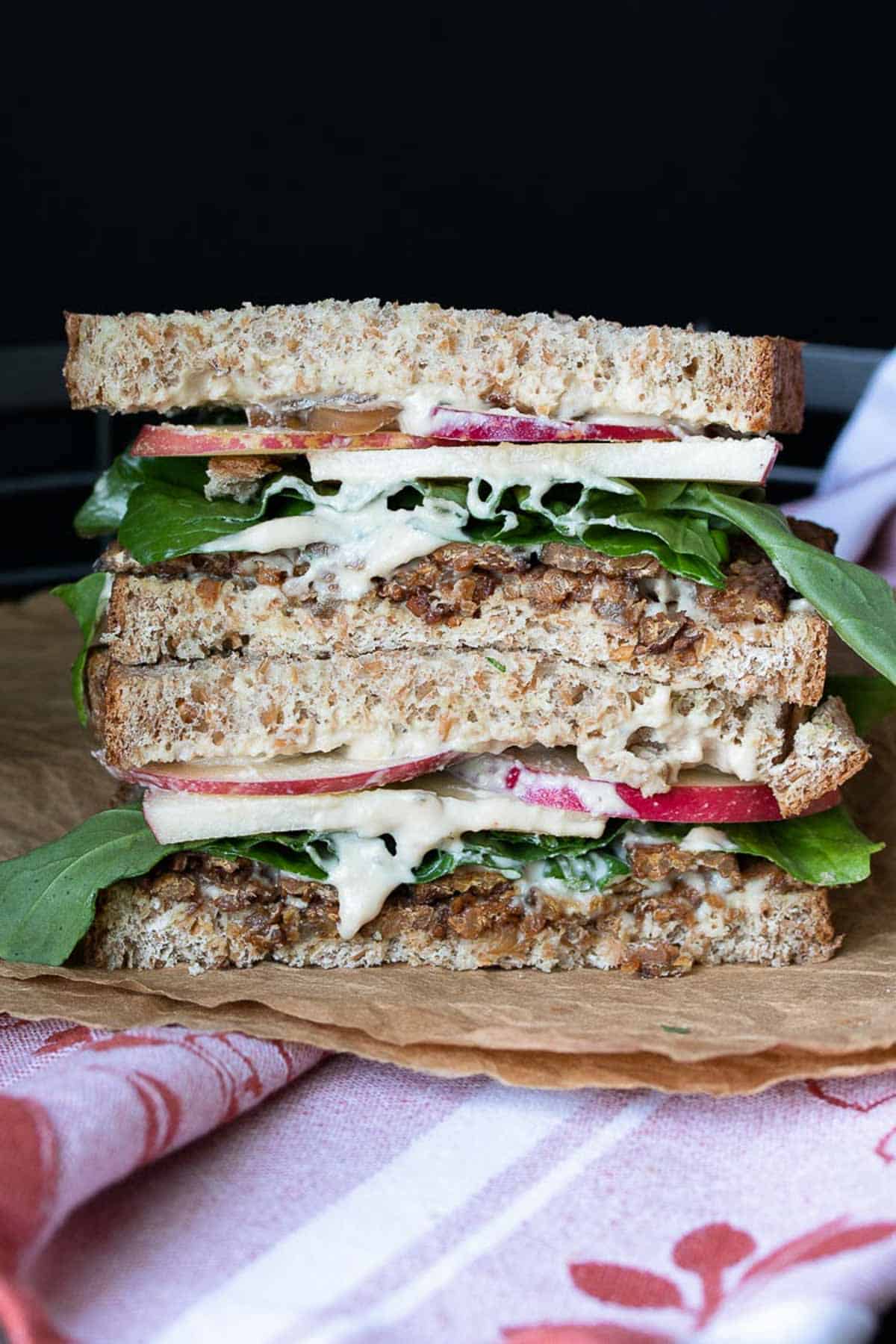two halves of a tempeh sandwich stacked.