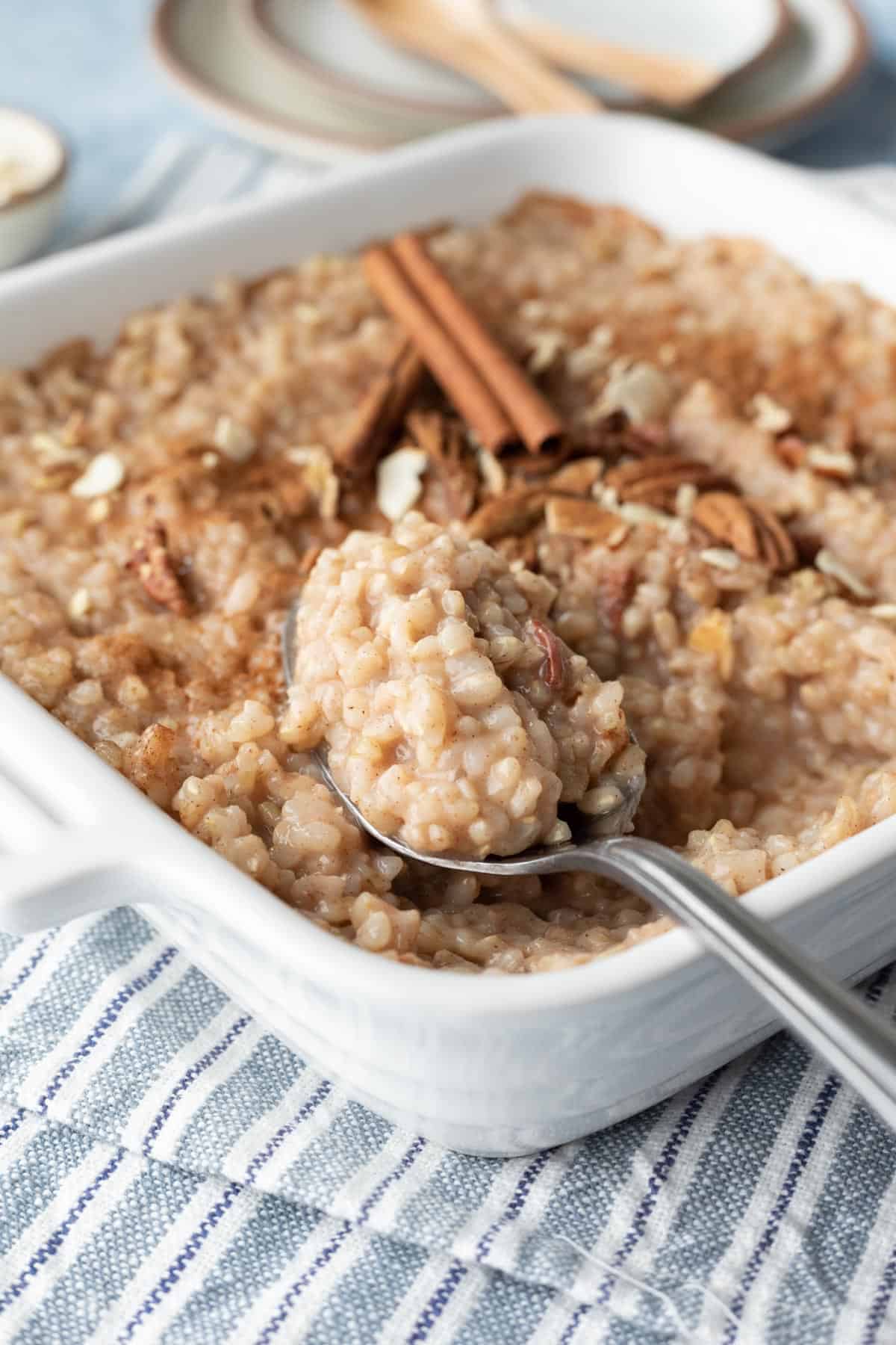 a spoon scooping up brown rice pudding made with almond milk.