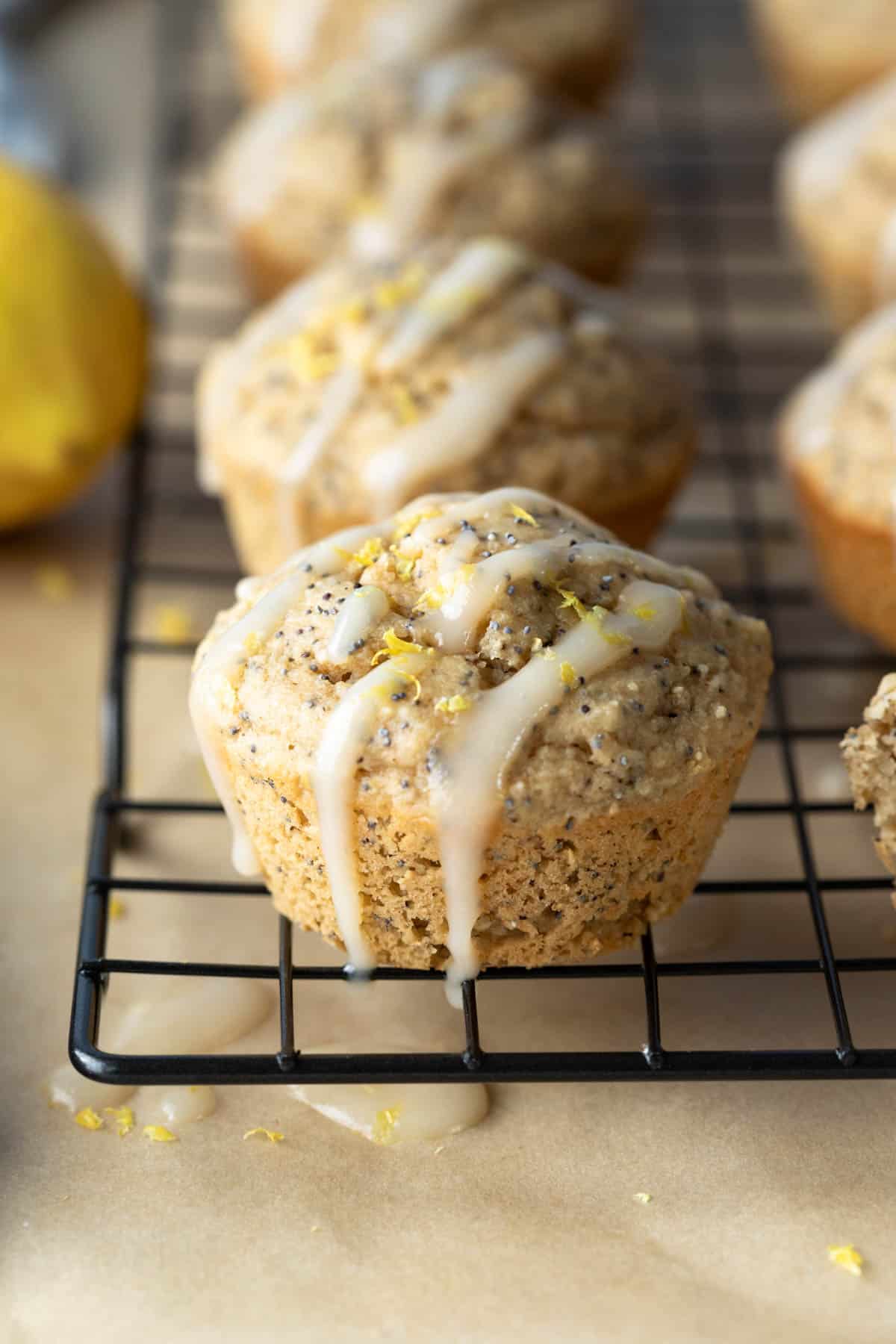 close up photo of healthy lemon poppy seed muffin drizzled with dairy-free icing.
