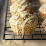 close up of muffins lined up on a cooling rack with icing on top.