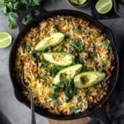 cheesy vegan skillet bake topped with avocado and cilantro.