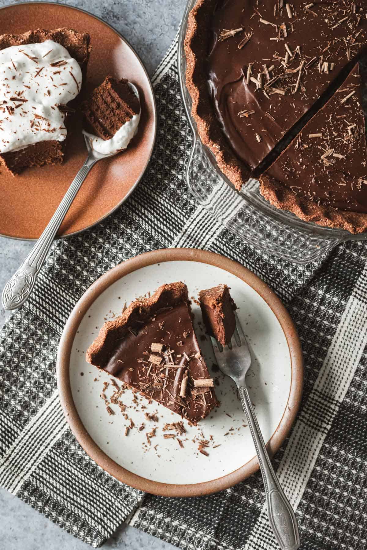 slice of chocolate pie topped with chocolate shavings on a plate.