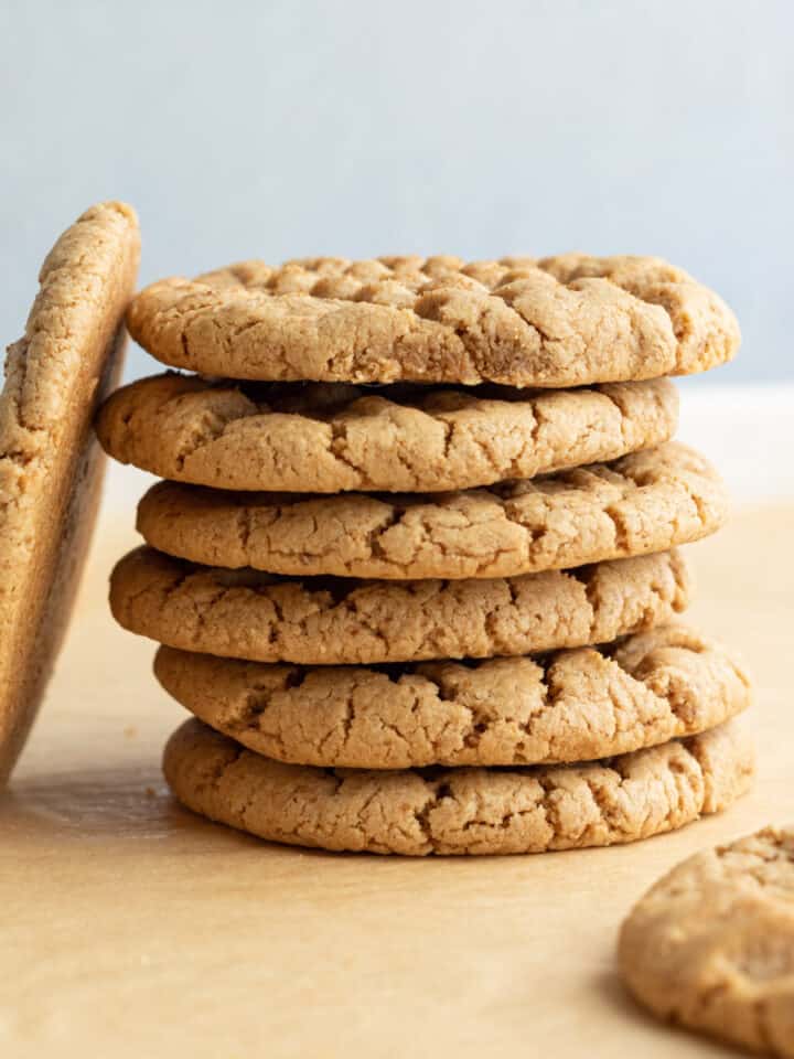 a stack of healthy peanut butter cookies on parchment paper.