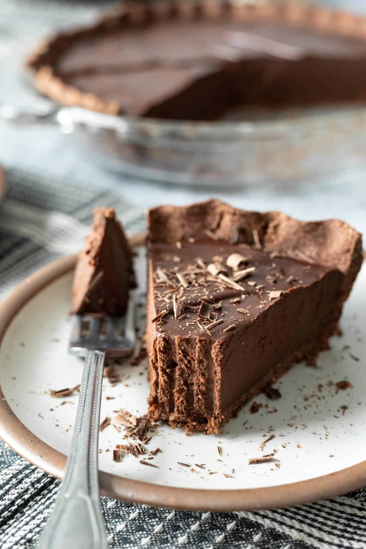 a slice of dark chocolate pie on a small plate showing dense texture.