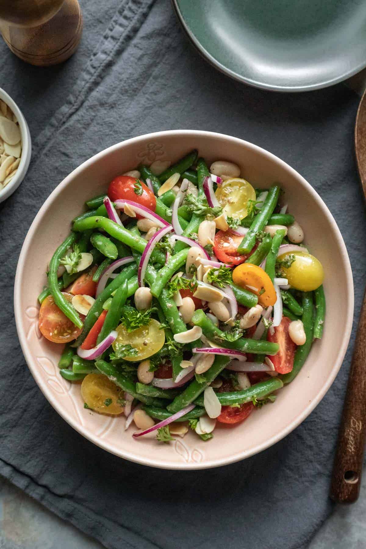 colorful Italian green bean and tomato salad in a pink serving bowl.