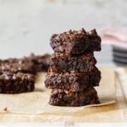 a stack of almond flour brownies showing their fudgy texture .