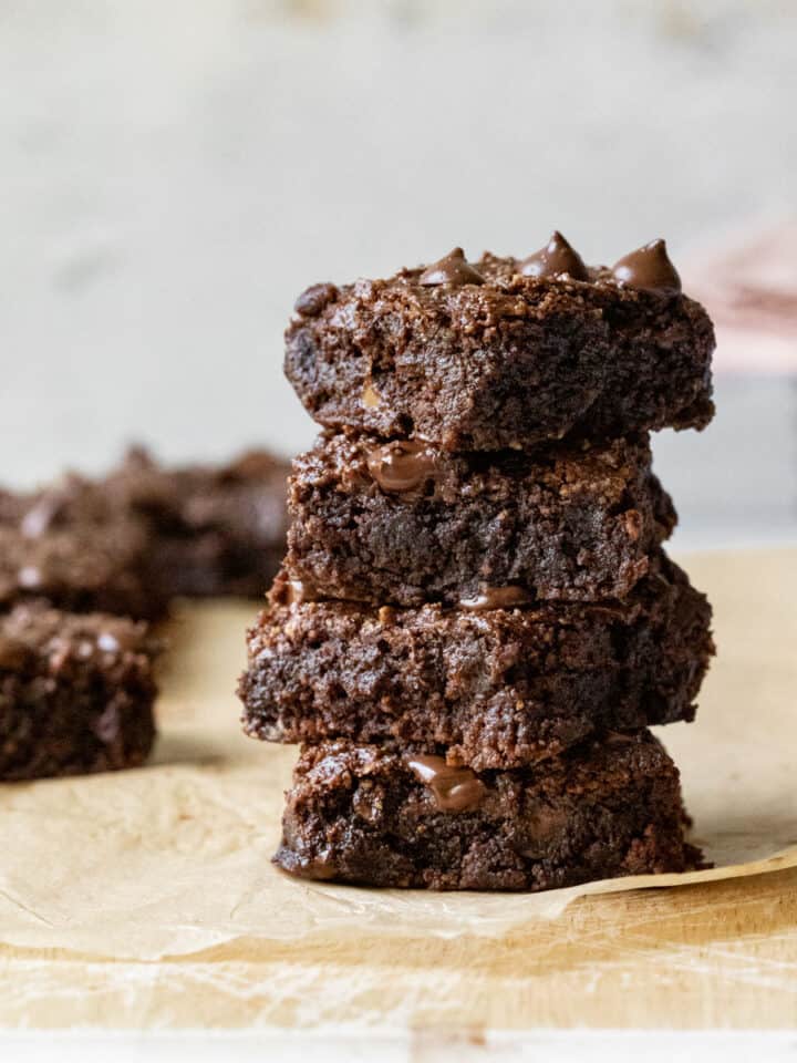 a stack of almond flour brownies showing their fudgy texture .