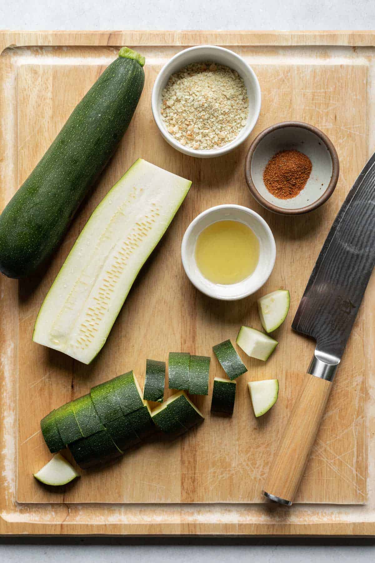 chopping zucchini on a large cutting board.