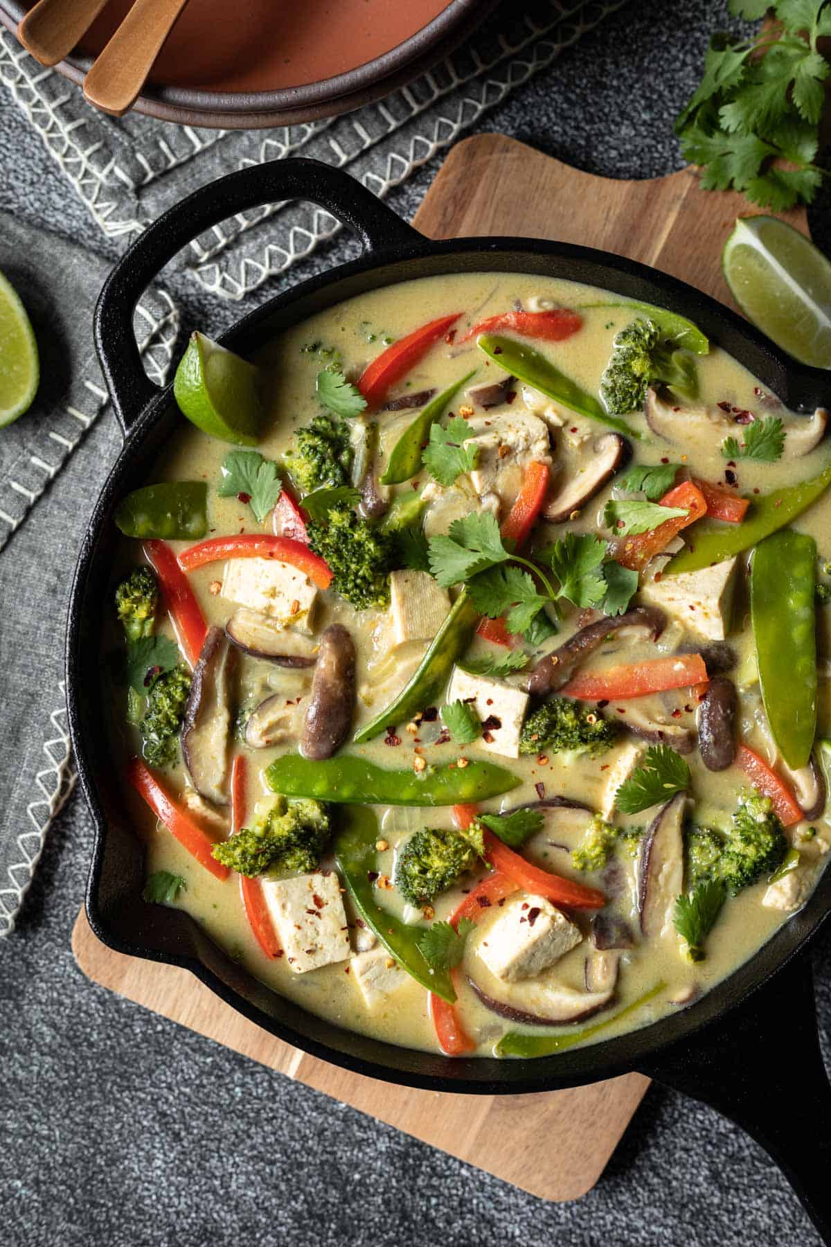 colorful green curry tofu in a cast iron skillet.
