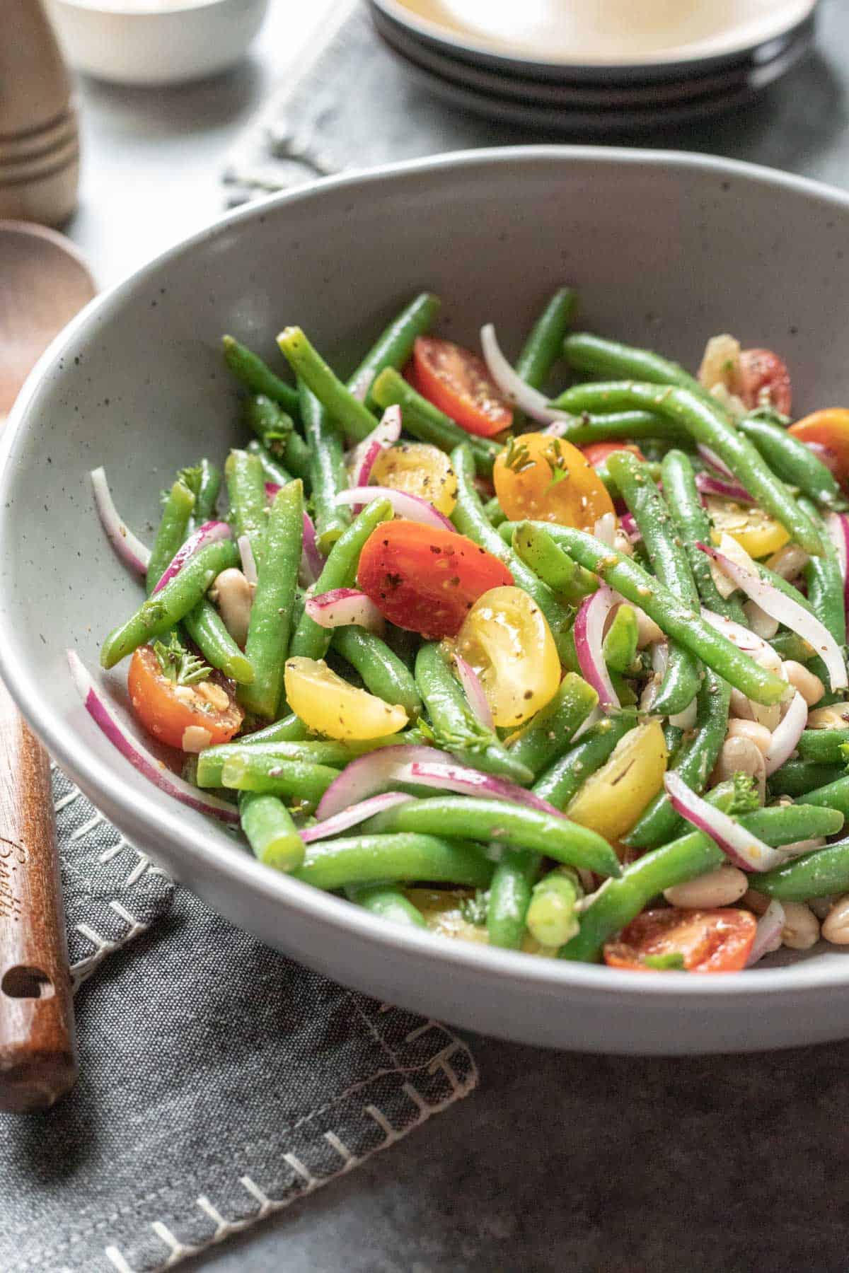 bright side photo of colorful green bean salad in a large serving bowl.