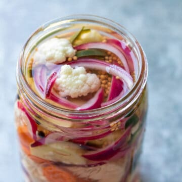 Looking into the top of a jar of colorful mixed pickled vegetables.