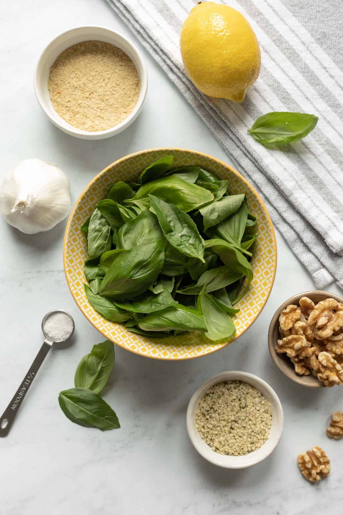 ingredients for pesto laid out on a marble background.
