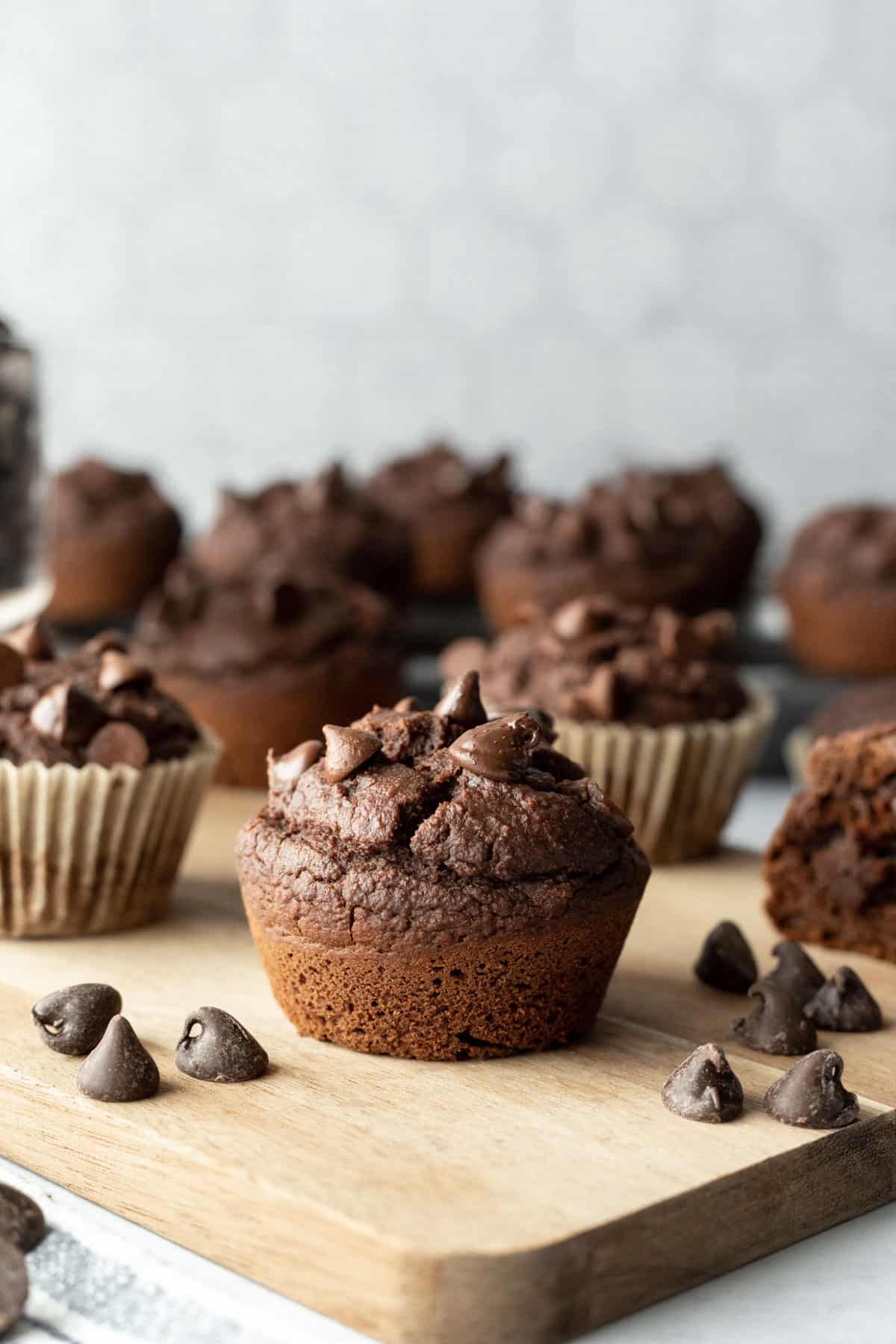 Dark chocolate muffins on a cutting board.