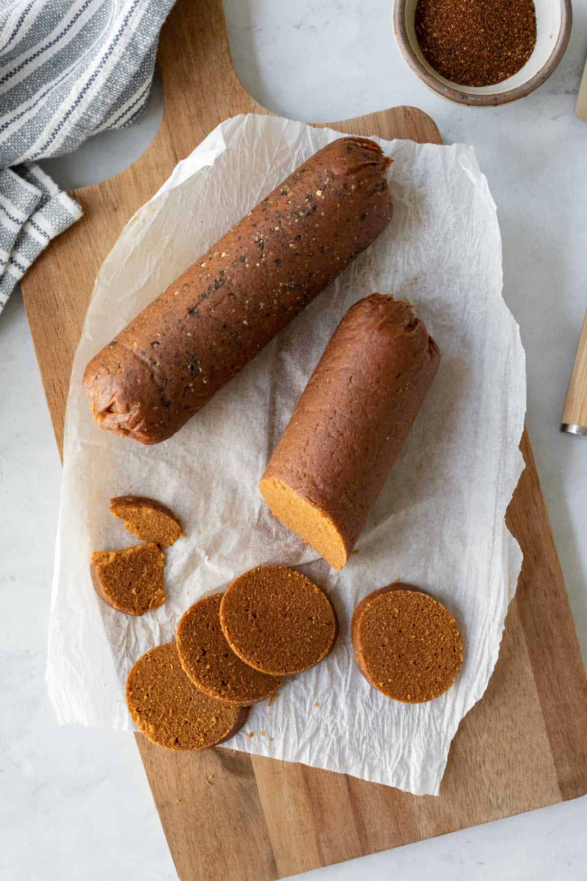 Spicy seitan chorizo logs sliced on a cutting board.