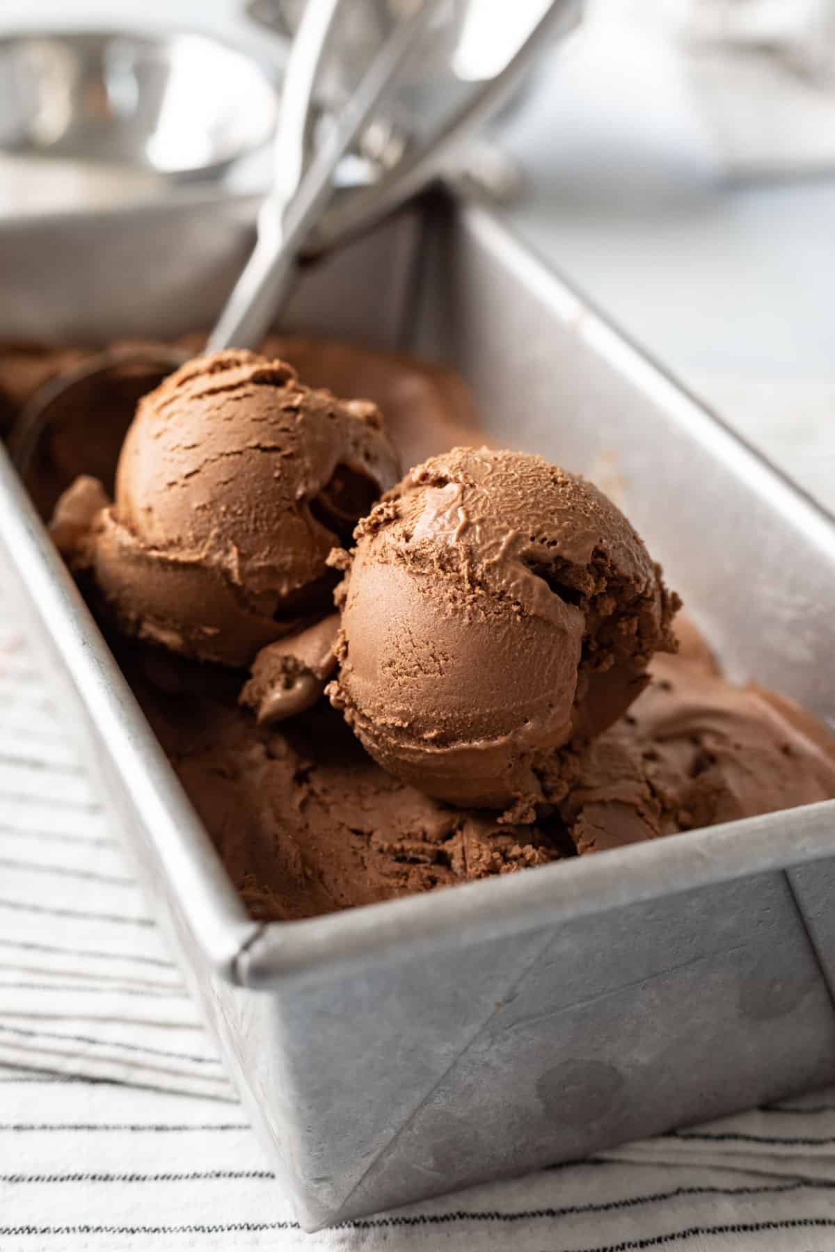 two scoops of nut-free vegan chocolate ice cream in a metal pan.