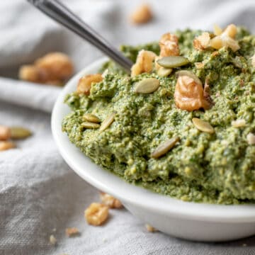 close up view of thick dill pesto in a small white bowl.