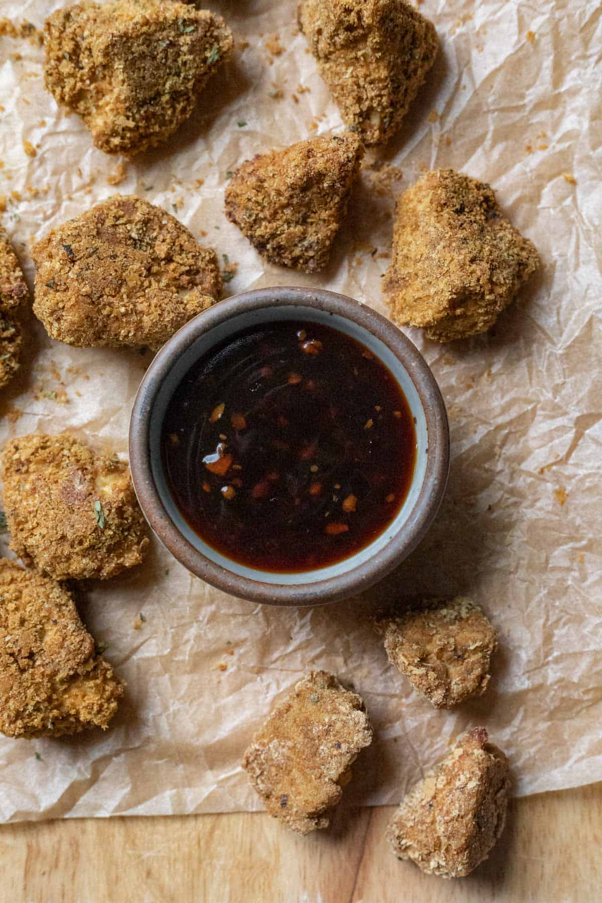 nuggets on a cutting board showing some that are oil-free and some with oil in the breading.