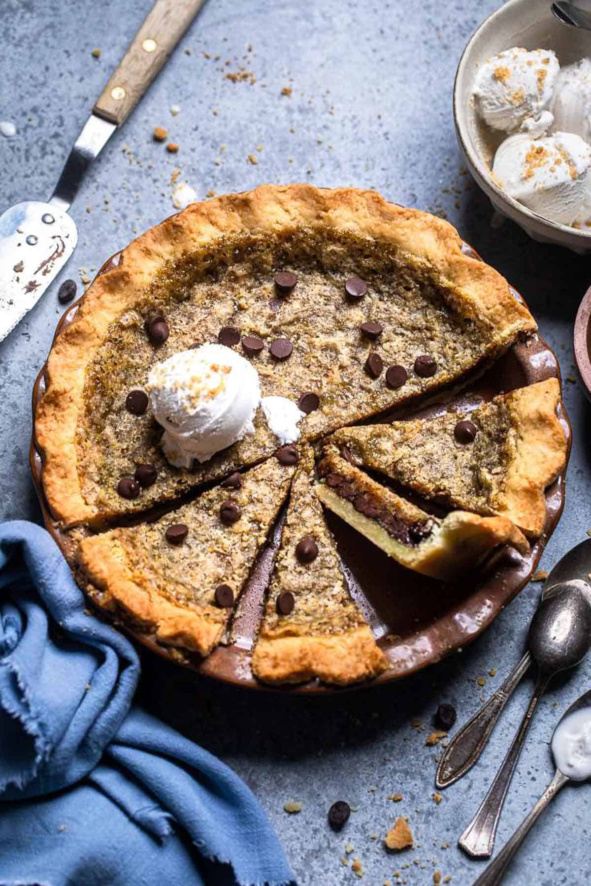 rich chocolate cookie pie with a thick crust in a pie plate against a blue background.