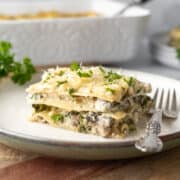 a serving of vegan white lasagna with spinach and mushrooms on a plate.