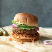Air fryer vegan burger on a bun with kimchi, lettuce, onion, and mustard.