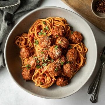 large serving bowl filled with vegan spaghetti and meatballs.