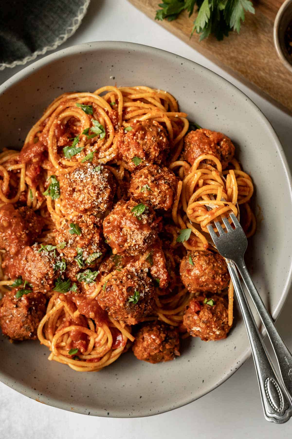 A large serving bowl filled with spaghetti, sauce, and vegan meatballs.