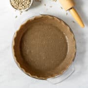 overhead view of unbaked sunflower seed pie crust in glass pie plate.