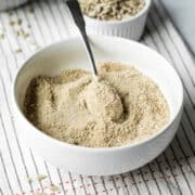 looking down into a white bowl filled with finely ground homemade sun flour, or sunflower seed flour.