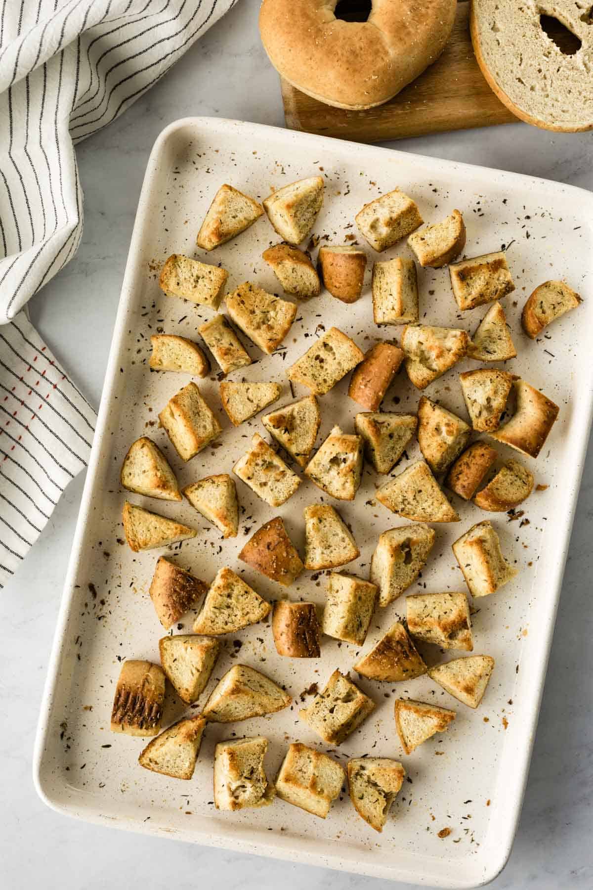 freshly baked bagel croutons on a baking sheet.