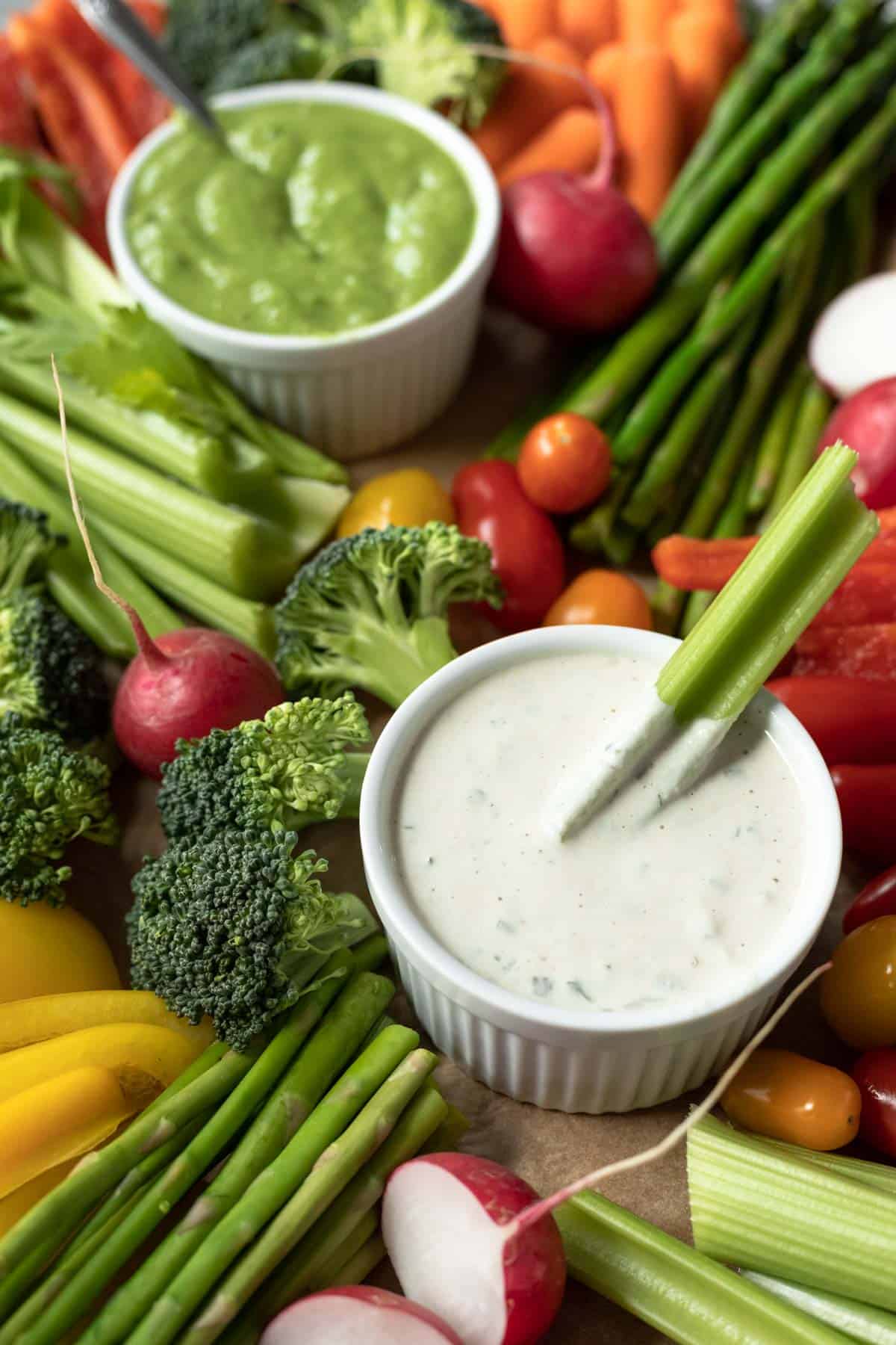 close up look at different vegetables surrounding a bowl of dairy-free ranch dip on a homemade veggie tray.