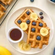 two waffles topped with blueberries and banana.