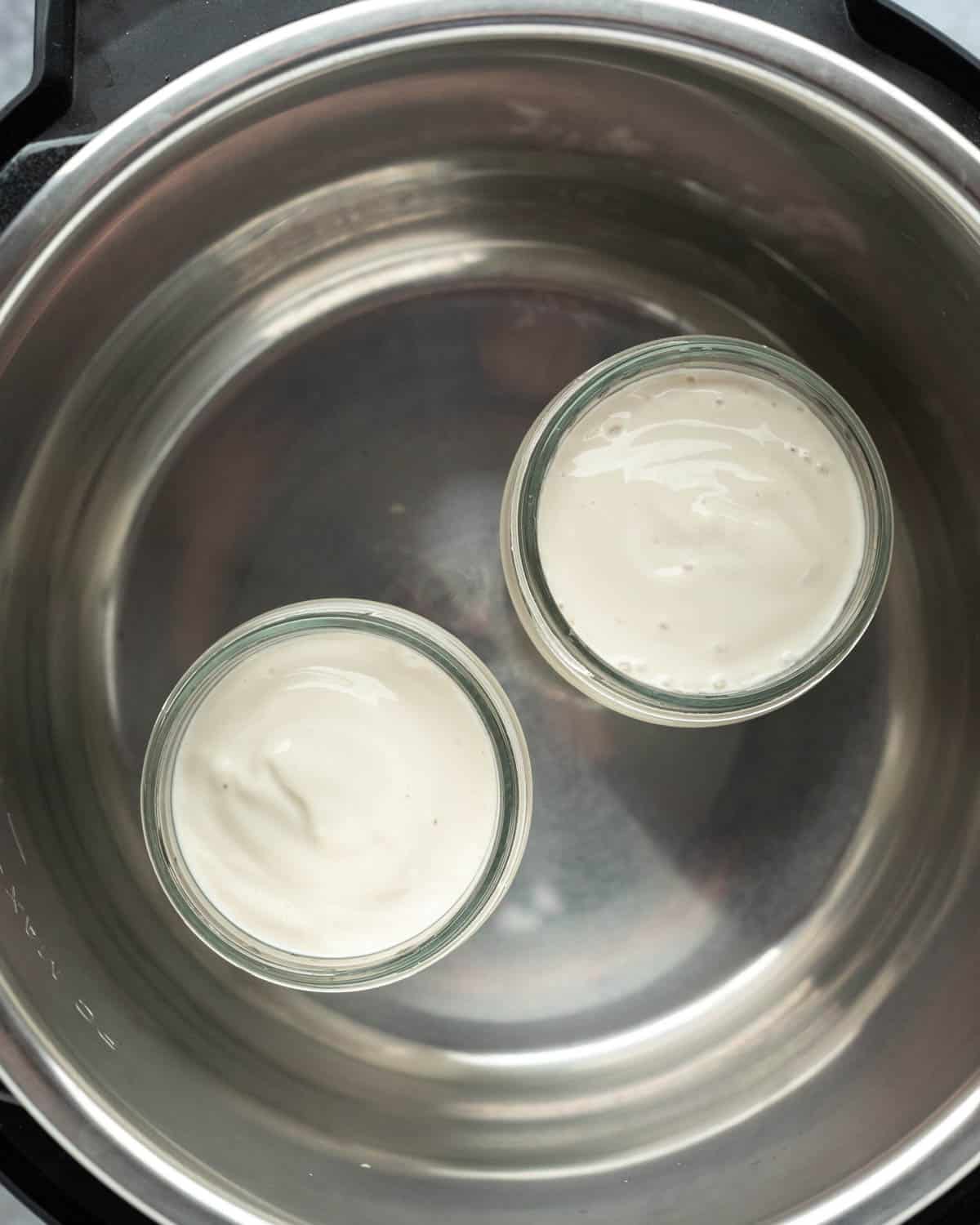 looking down into the Instant Pot showing two jars of homemade tofu yogurt.
