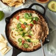 cheesy bean dip topped with avocado, jalapeno, and fresh cilantro.