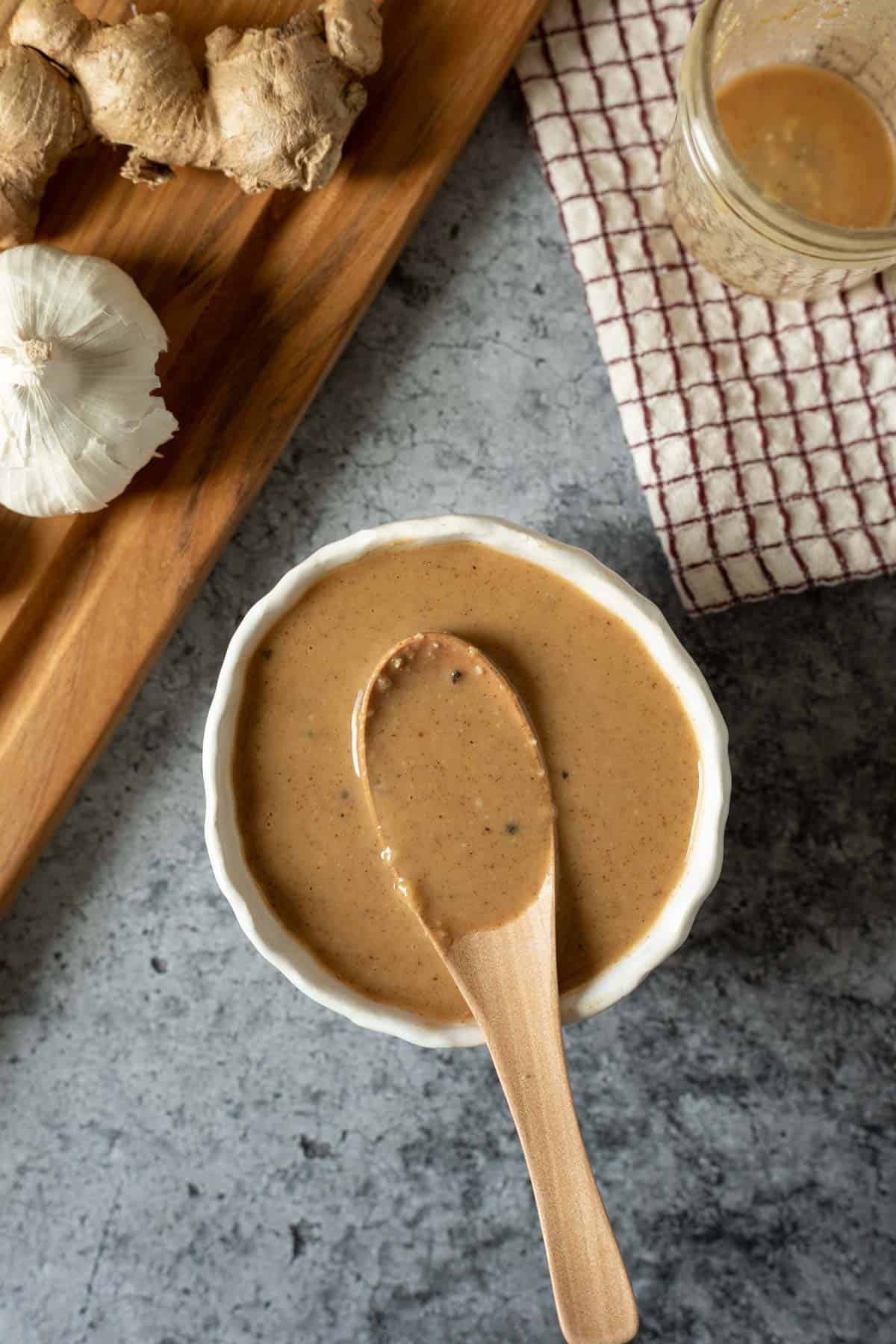 wooden spoon resting in a bowl full of miso sauce.