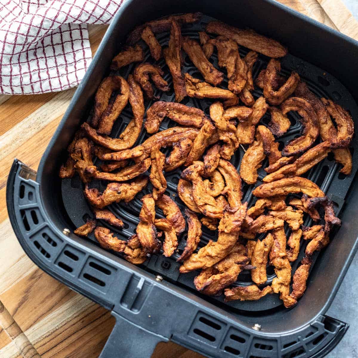 freshly air fried soy curls inside air fryer basket.