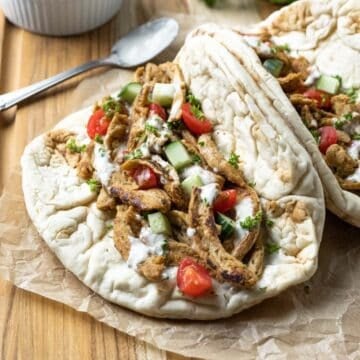 Flatbread pita sandwich filled with soy curl chicken, Mediterranean flavors, and an easy dairy-free yogurt sauce.