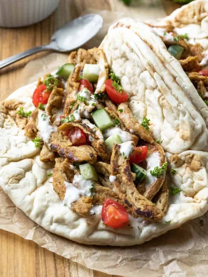 Flatbread pita sandwich filled with soy curl chicken, Mediterranean flavors, and an easy dairy-free yogurt sauce.