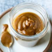 Golden brown date caramel in a glass jar.