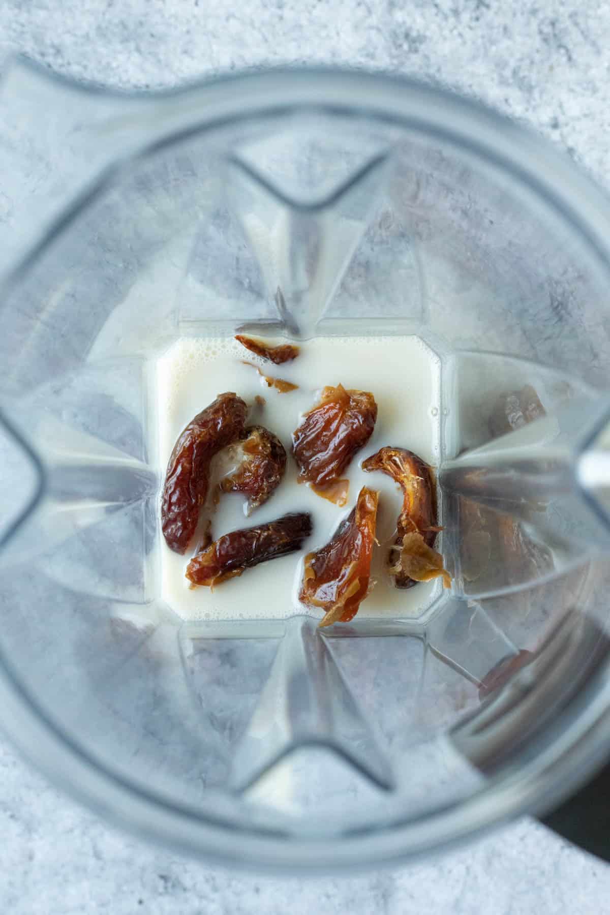 Dates and oat milk in a blender.