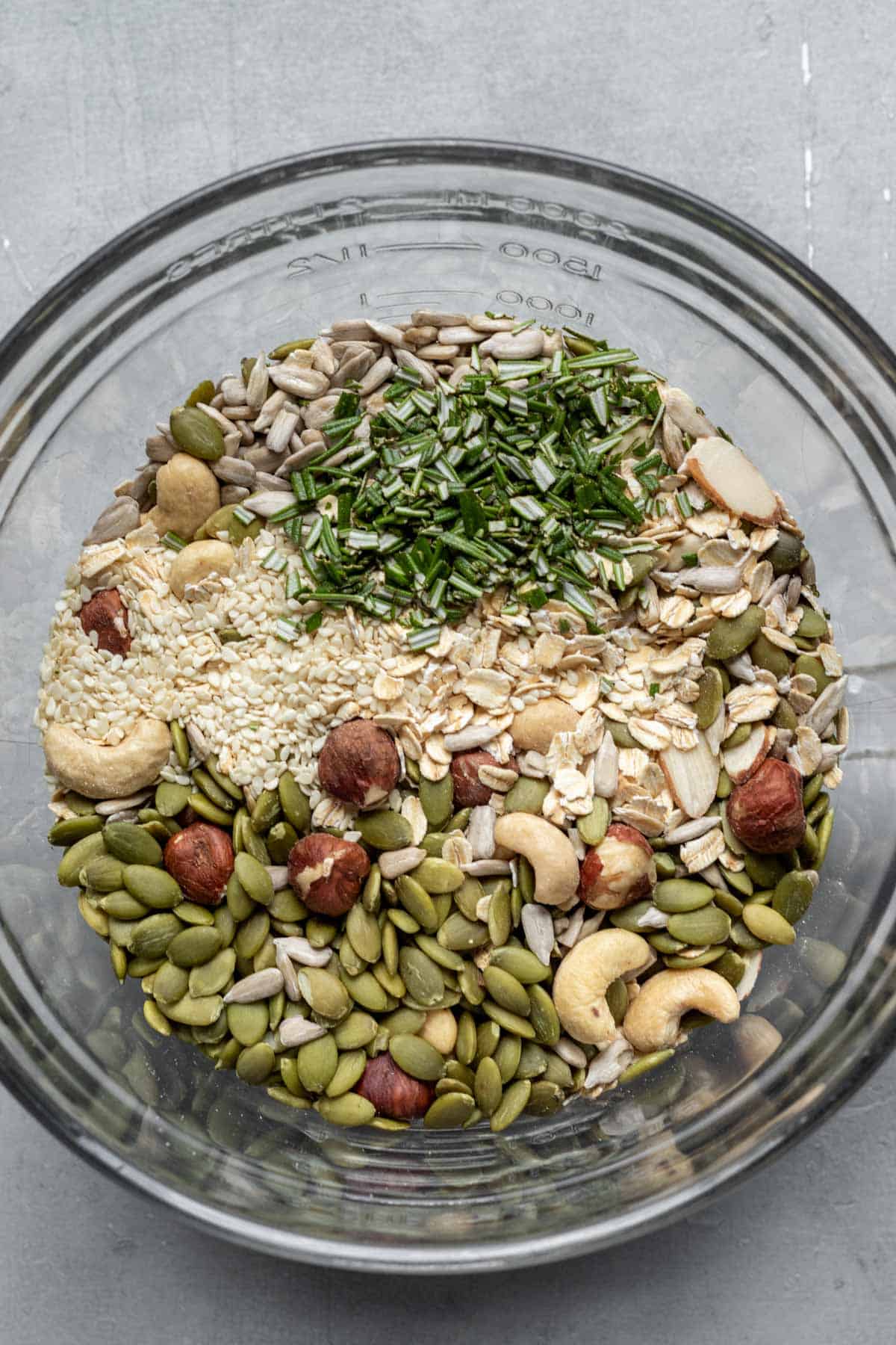 ingredients for savory granola in a glass mixing bowl.