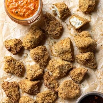 crispy breaded tofu nuggets with dipping sauces on parchment paper.
