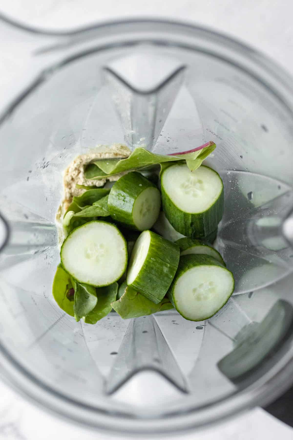 8 ingredients for cucumber smoothie inside a blender jar.