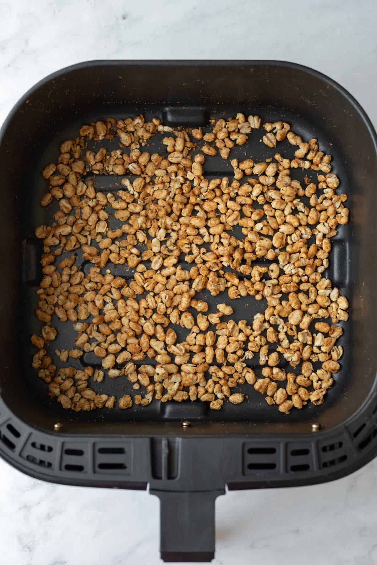 Crispy navy beans inside an air fryer basket.