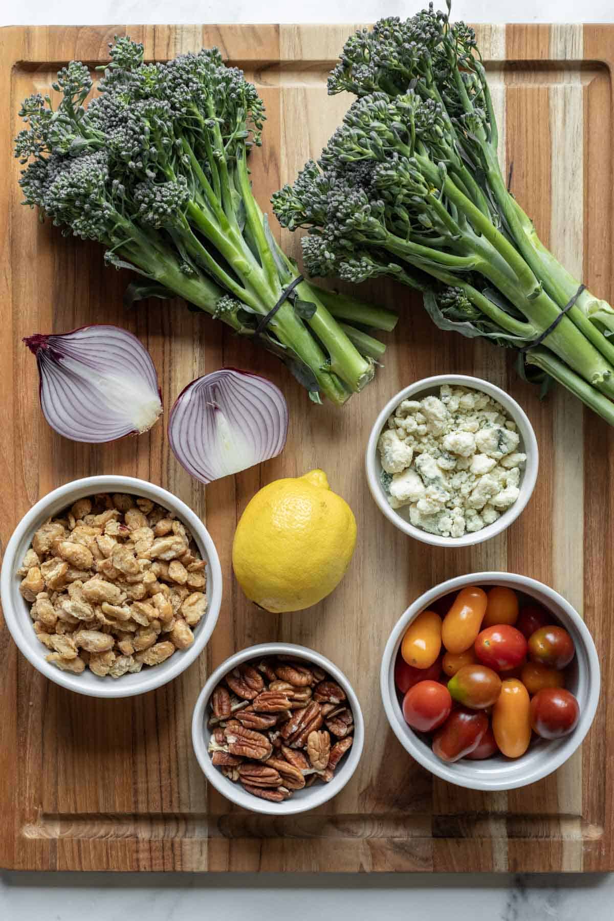 Ingredients needed for broccolini salad laid out on a cutting board.