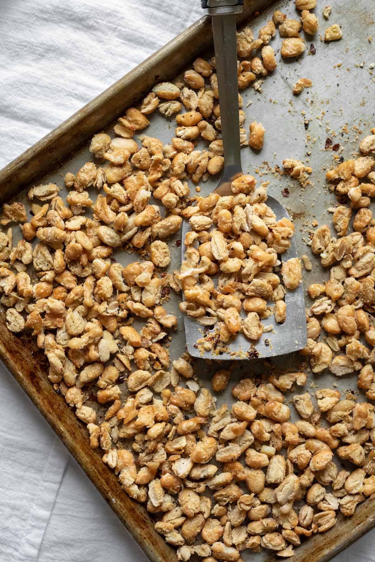 Roasted white beans on a large baking sheet.