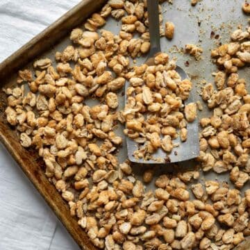 Crispy roasted cannellini beans spread out on a sheet tray.